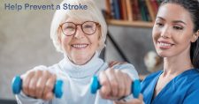 What Can be Done to Prevent a Stroke? Picture of an elderly Caucasian female exercising with lightweight dumbbells in her hands and with assistance from a Hispanic female physical therapist.a